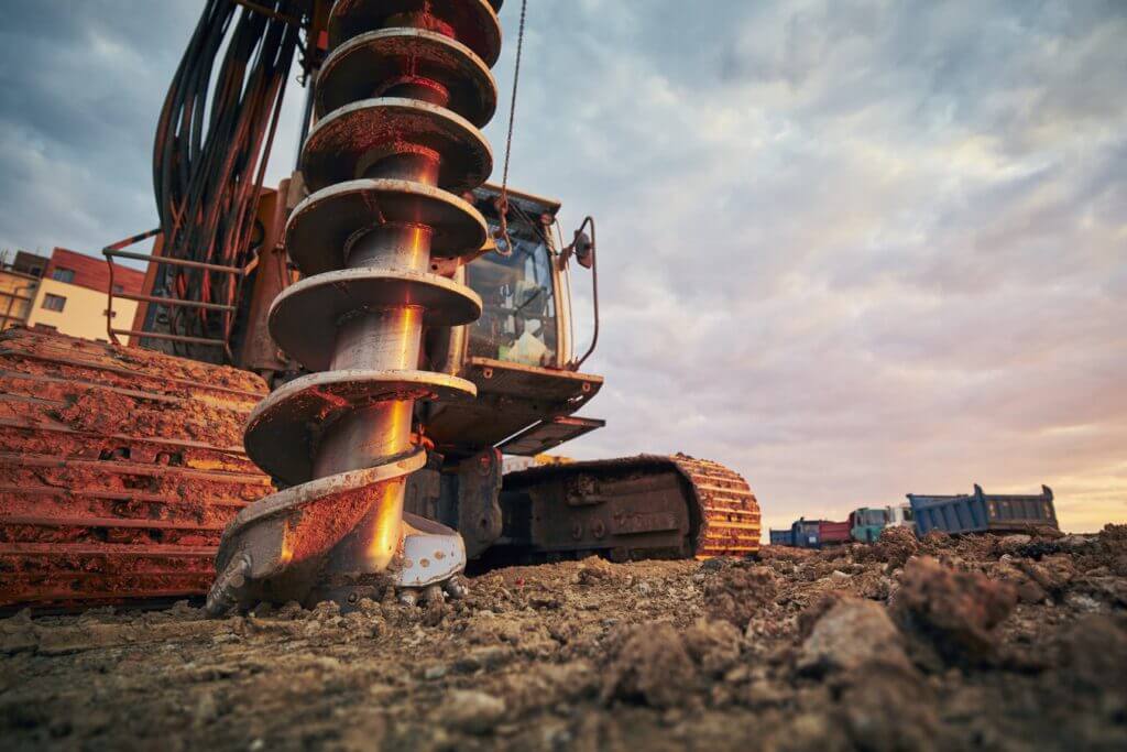 a drill digs as the sun sets