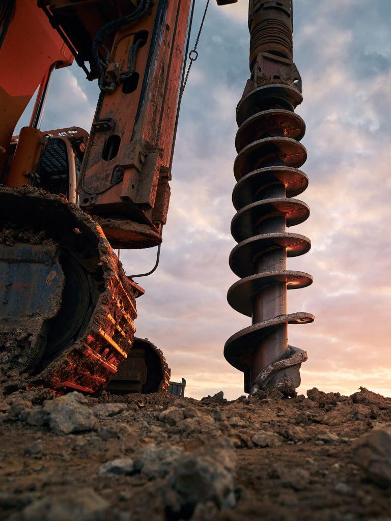 a drill digs as the sun sets