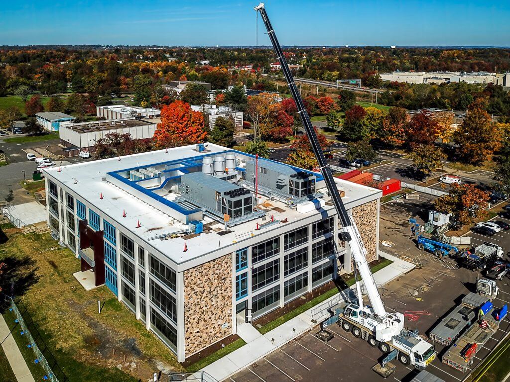 a custom manufacturer of advanced air handling equipment installs equipment on the roof of a business building