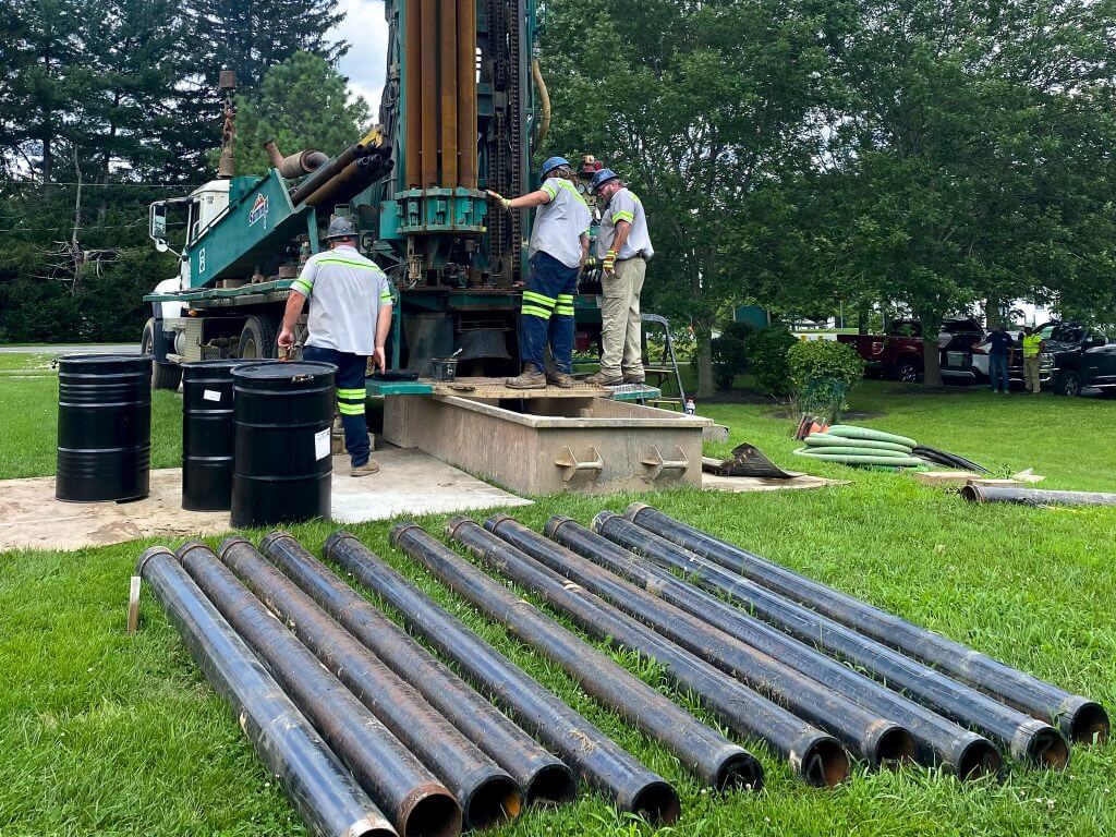 a group of people work together to drill